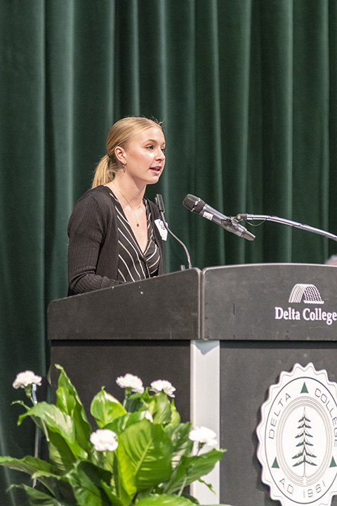 Olivia speaking at a podium at the Delta College Presidient's inauguration