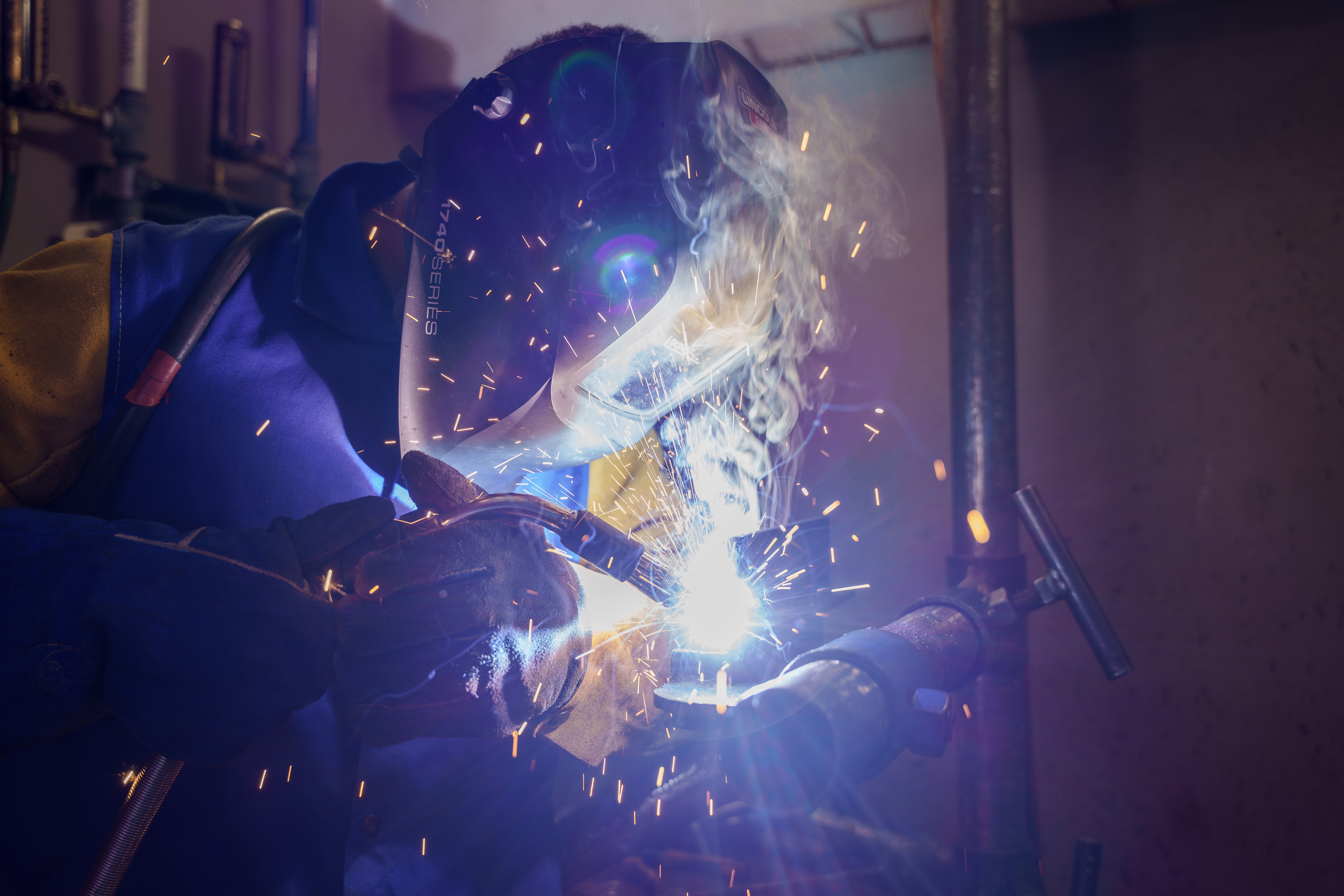 Delta College welding student actively welding a pipe