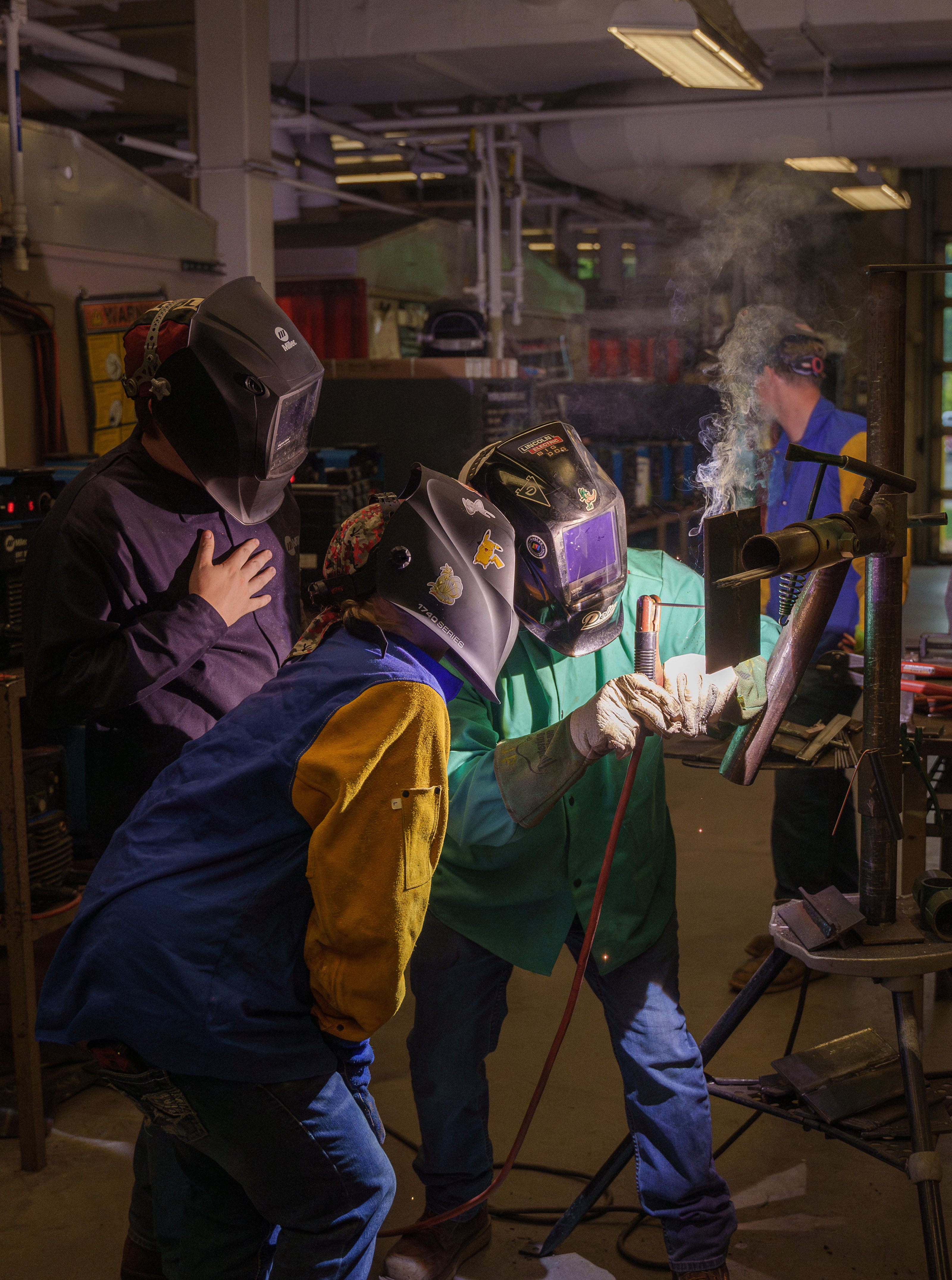 Delta College Welding Engineering Technology students wearing helmets while getting a lession from an instructor