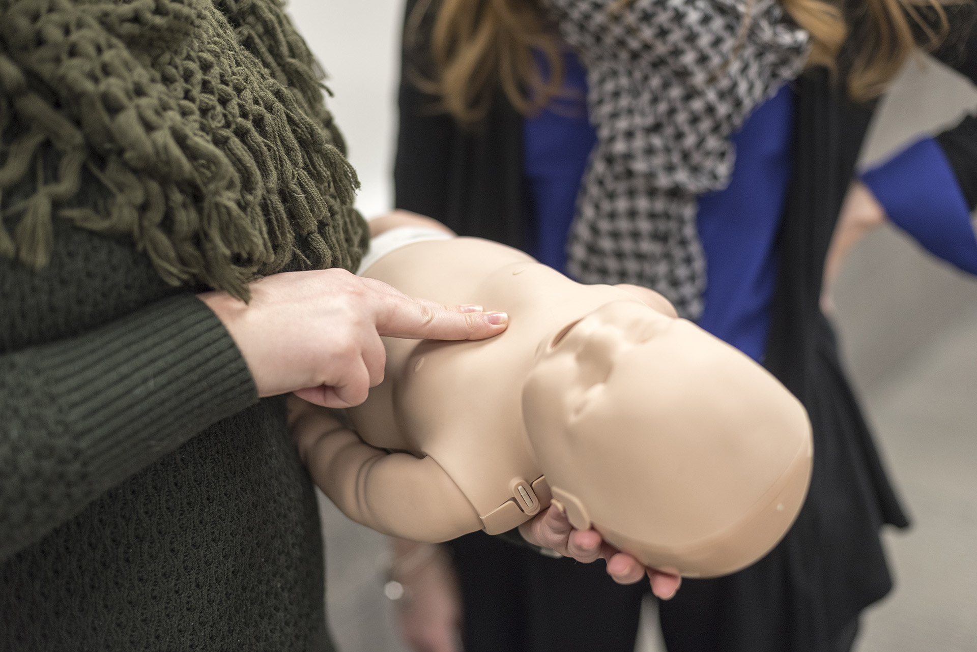 Students working with baby cpr manikin