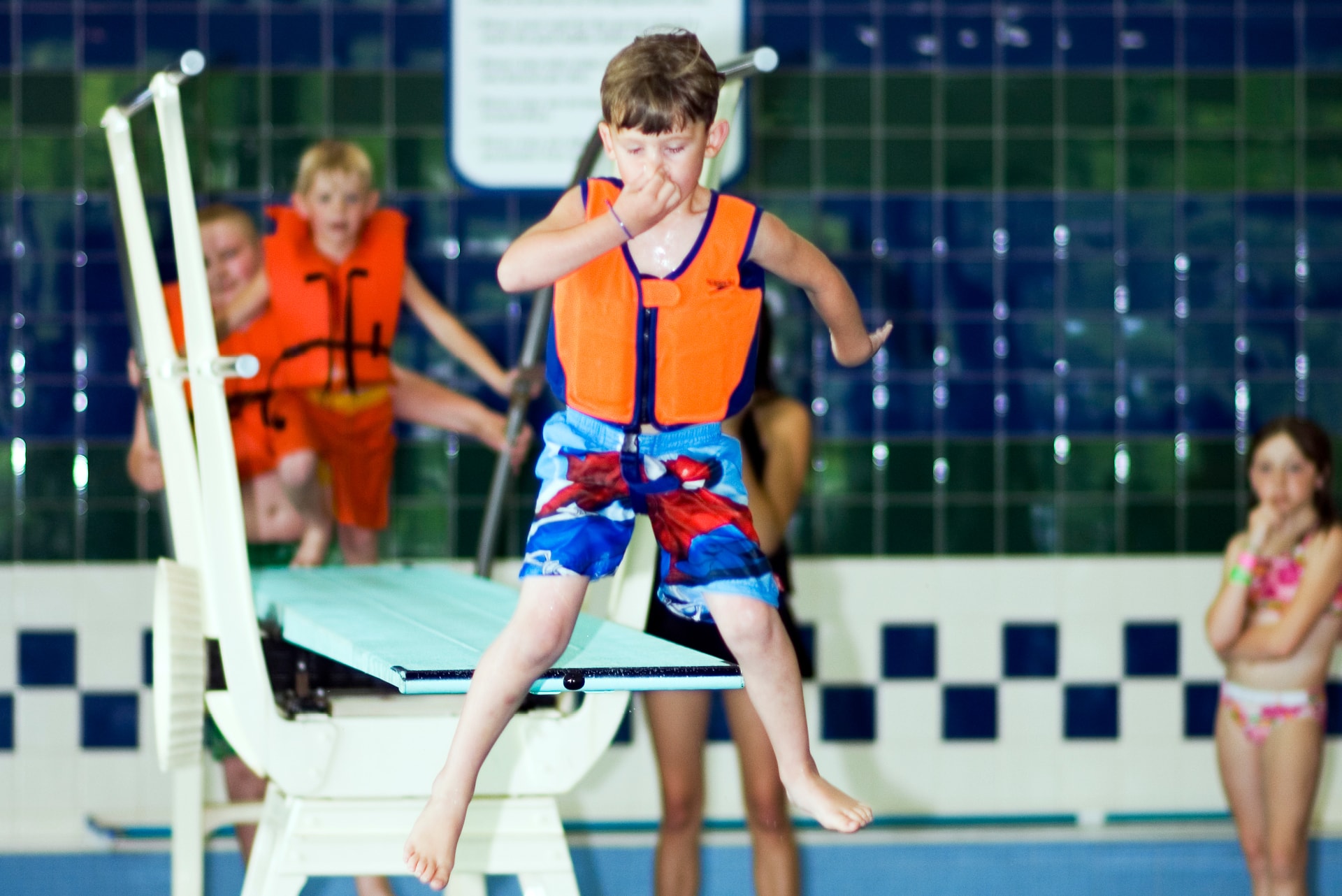 Child jumping off diving board. 